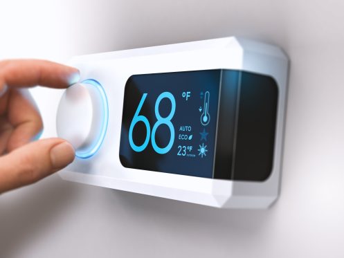 a smart thermostat with a hand turning the dial
