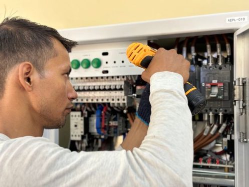 Licensed electrician performing electrical maintenance