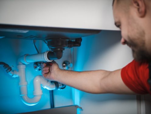 plumber repairing sink pipes