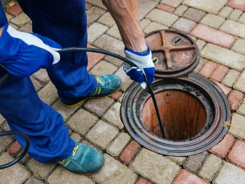 a technician inserting a camera into a sewer